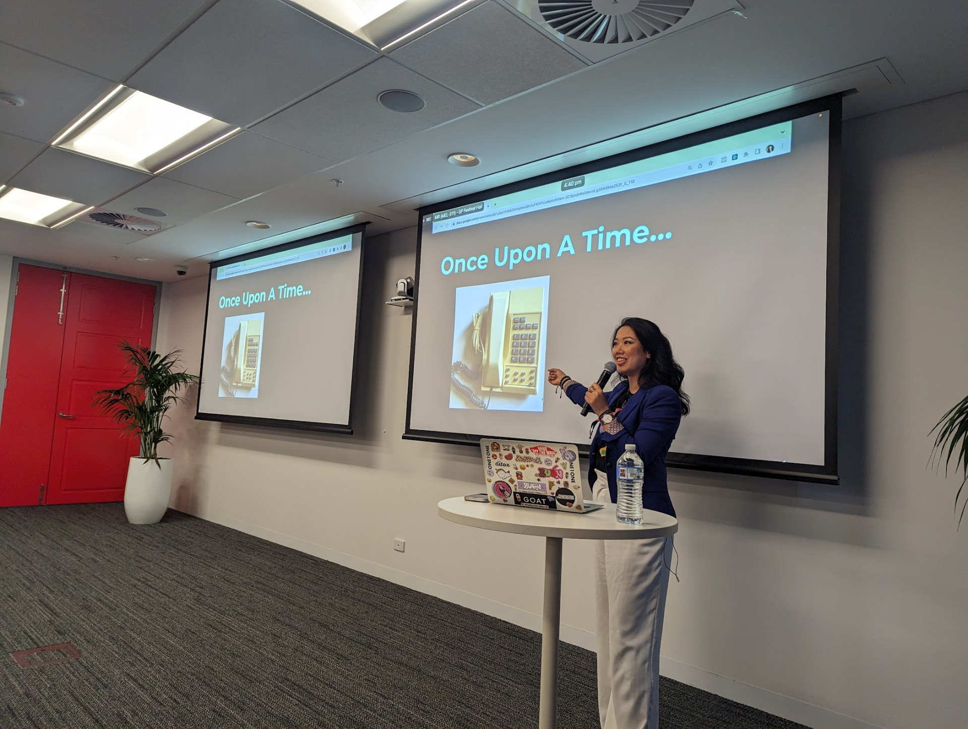 Thao Tran speaking on stage with Once Upon A Time presentation